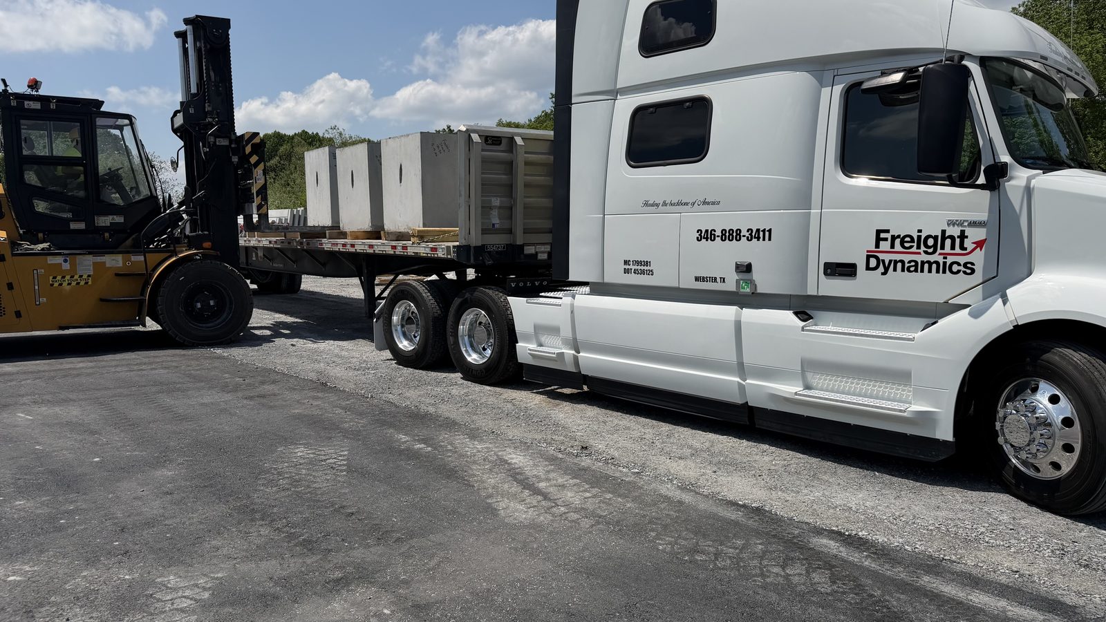 Forklift loading a Freight Dynamics flatbed