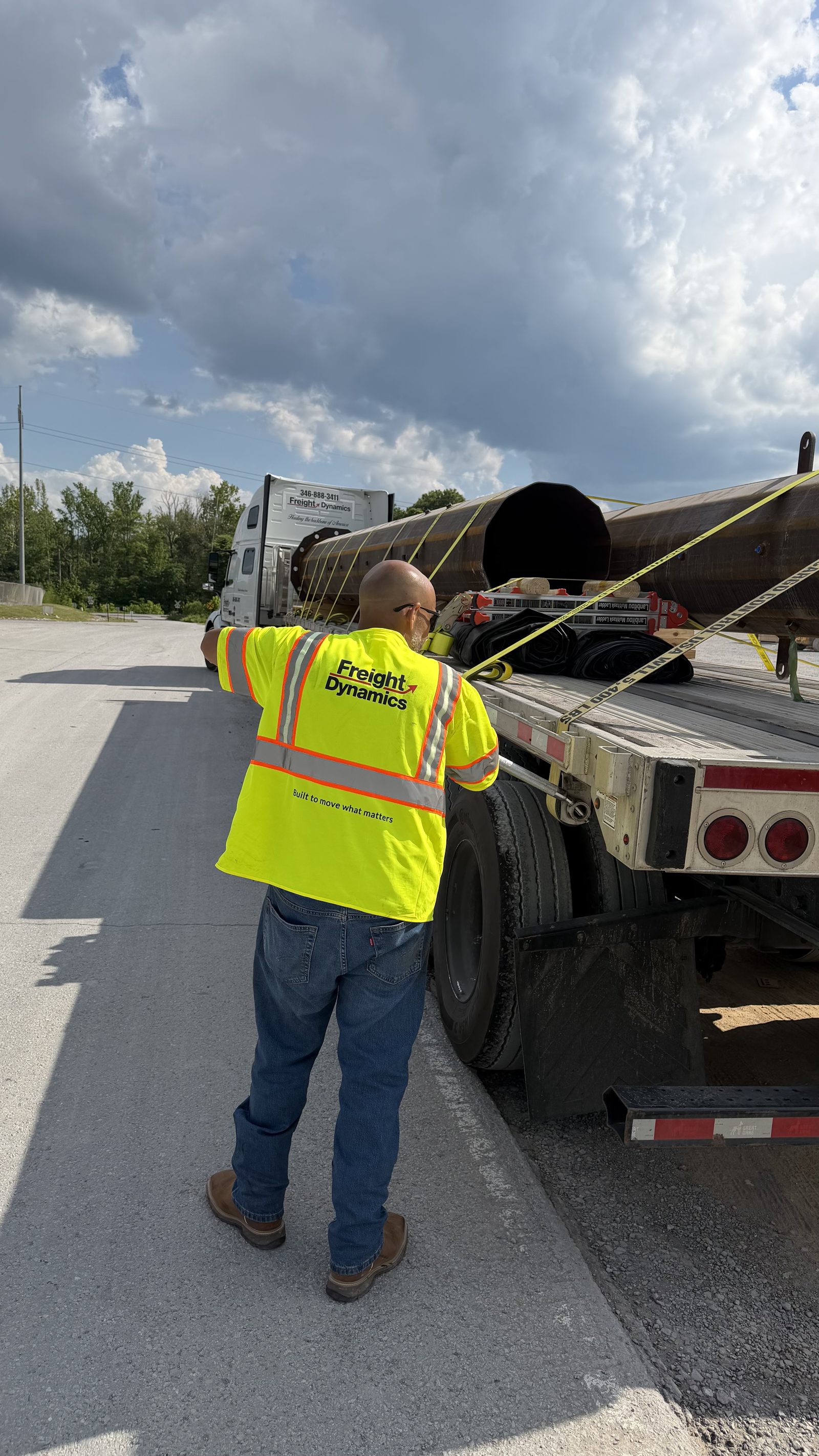 Driver securing straps on a flatbed load